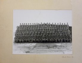 Soldaten auf einem Gruppenfoto vor einer Baracke