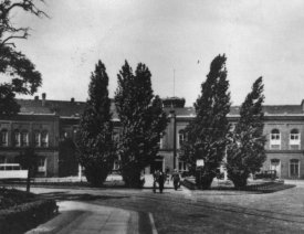 Bahnhof Küstrin Neustadt *4 - Blick aus der Schützenstraße. Im Vordergrund sind die Straßenbahngleise in der Schützenstraße zu erkennen. Links führen die Gleise weiter in die Bahnhofs- und dann in die Plantagenstraße. Vor dem Bahnhof ist links der Pappeln ein Onmibus zu erkennen. Hier eine Ansicht von 2011.